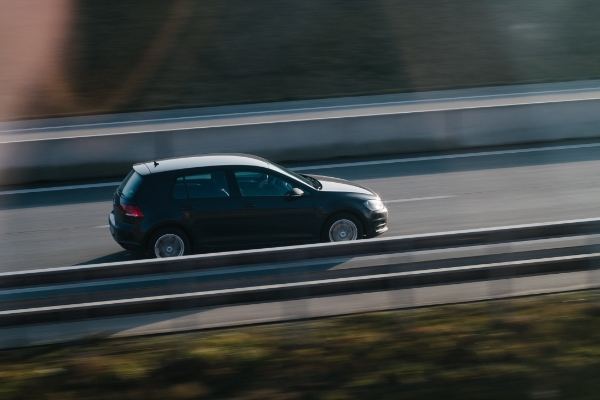 Black VW Golf driving at high speed along a road