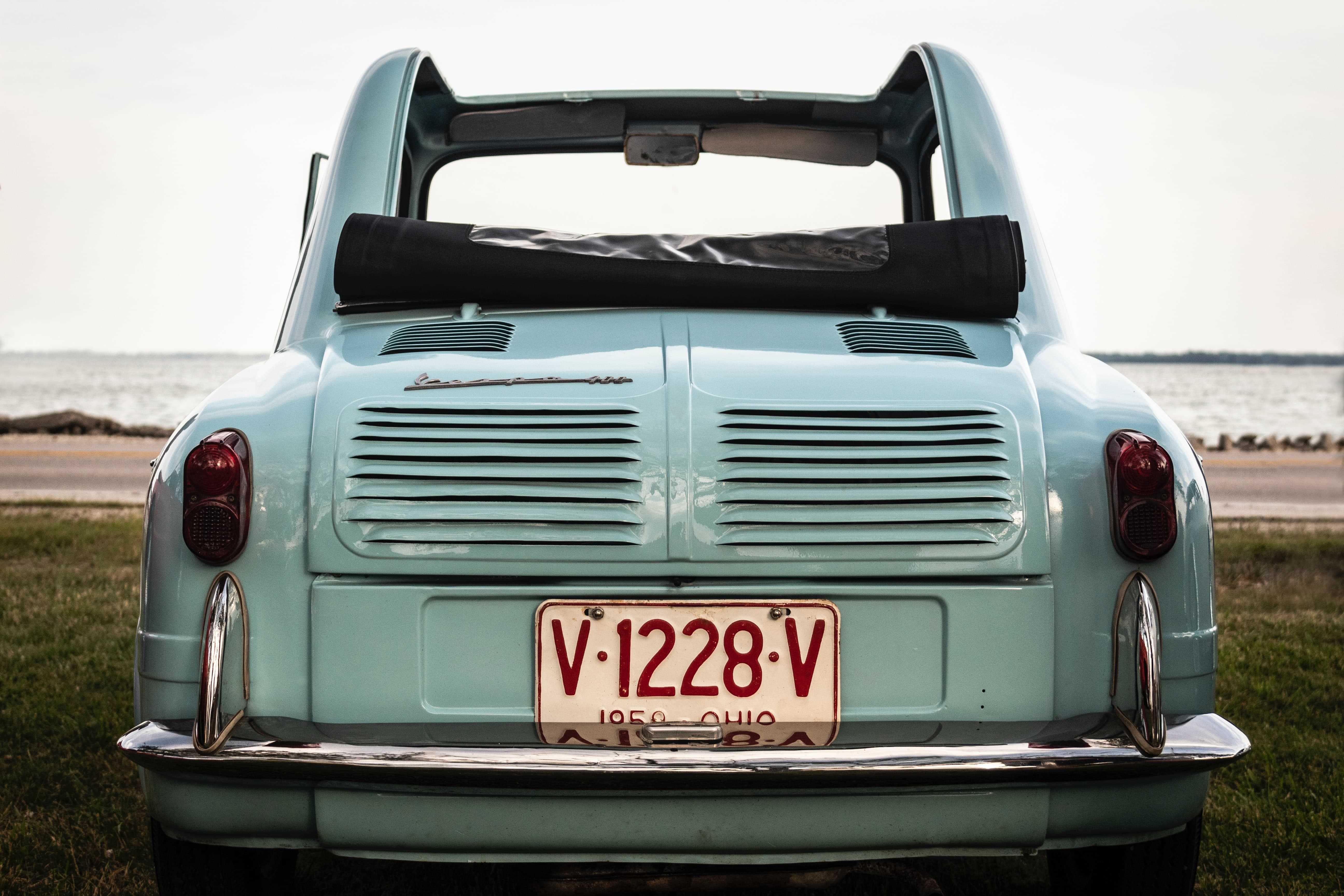 Heckansicht eines hellblauen Oldtimers am Wasser