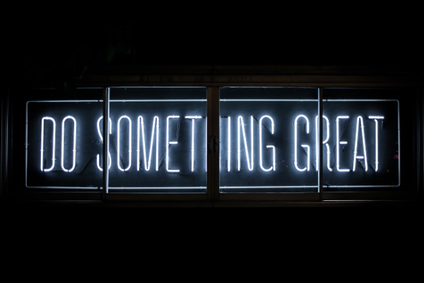 Letrero de ne&oacute;n con el texto 'Do something great' sobre un fondo oscuro