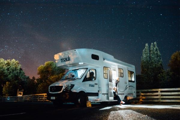Autocaravana blanca de noche bajo un cielo estrellado