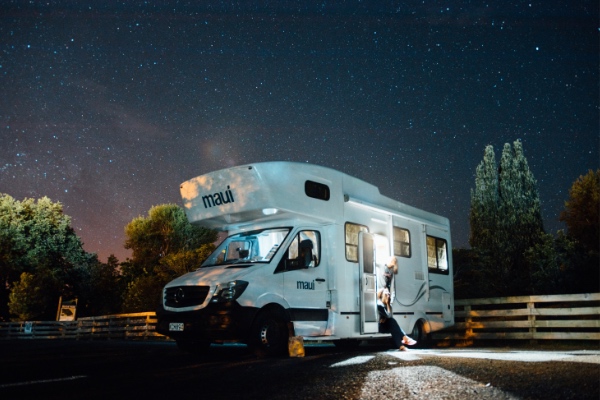 Autocaravana branca &agrave; noite sob um c&eacute;u estrelado