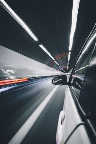 View from a moving car driving through a tunnel with motion blur
