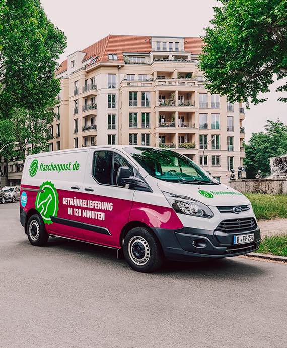 Camionnette de livraison Flaschenpost pour boissons devant un immeuble urbain