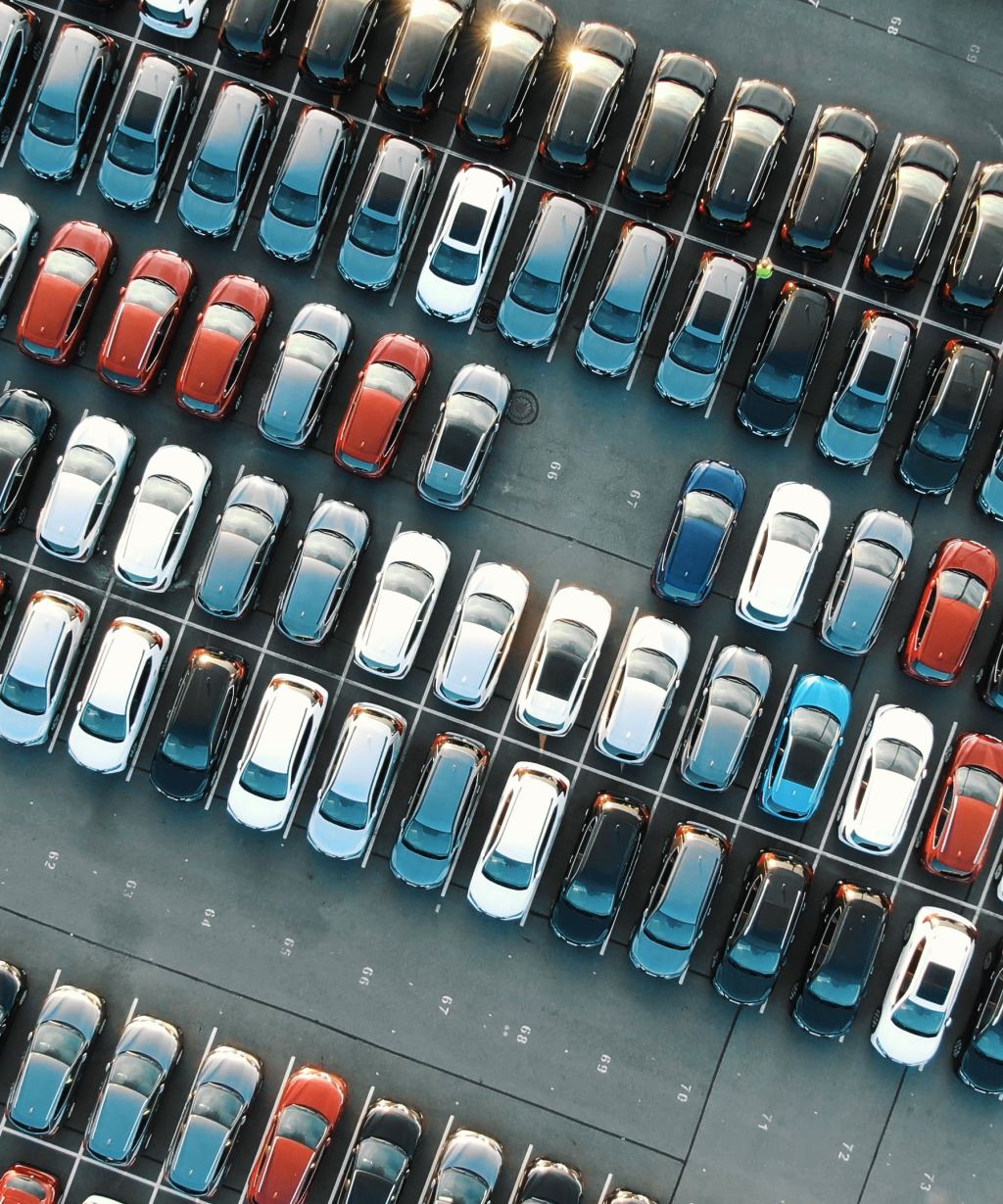 Luftaufnahme eines Parkplatzes mit dicht gereihten Fahrzeugen